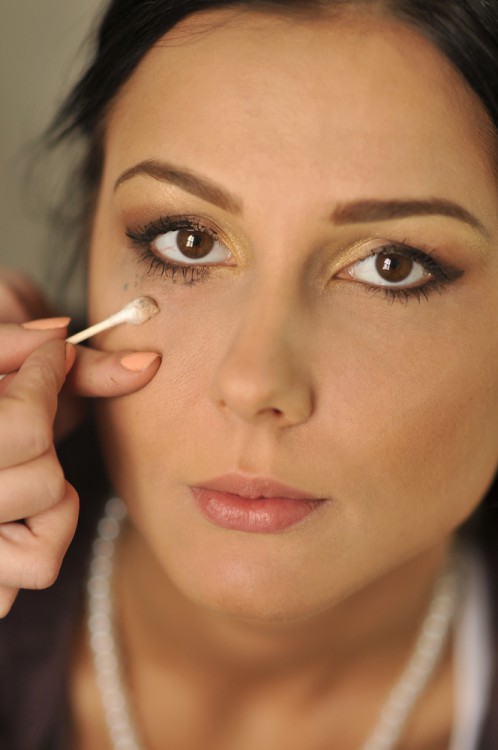 Woman using a q-tip to apply makeup