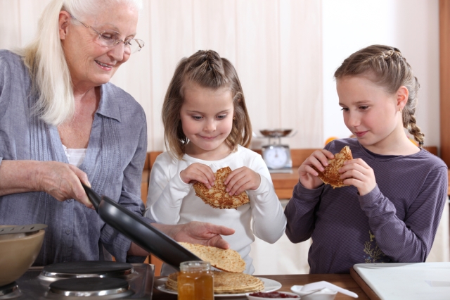 Grandmother cooking with her grand kids. 